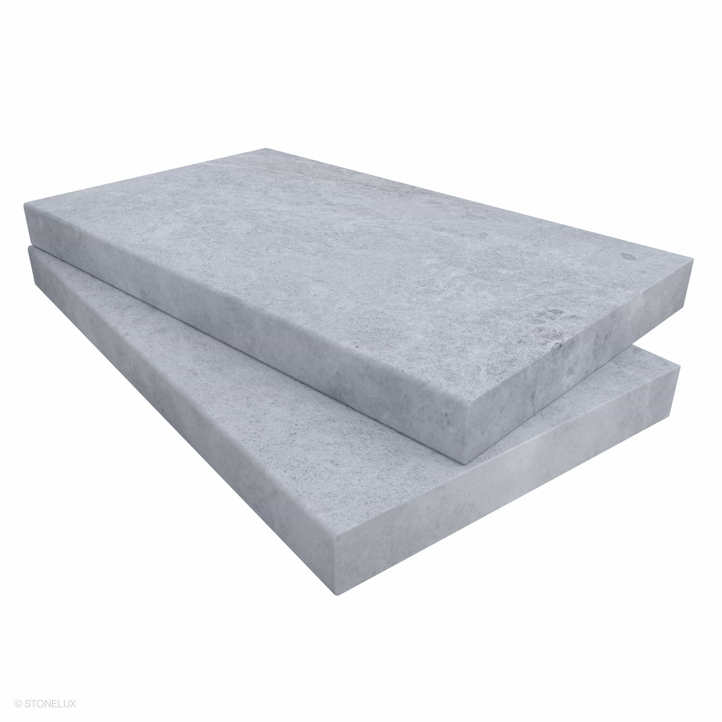 Close-up of STONELUX Tundra Grey Marble Sand Blasted 14x24x2 Eased Edge Coping. The marble features a sandblasted texture with subtle grey veining, showcasing an elegant and durable stone ideal for pool edges and wall caps.