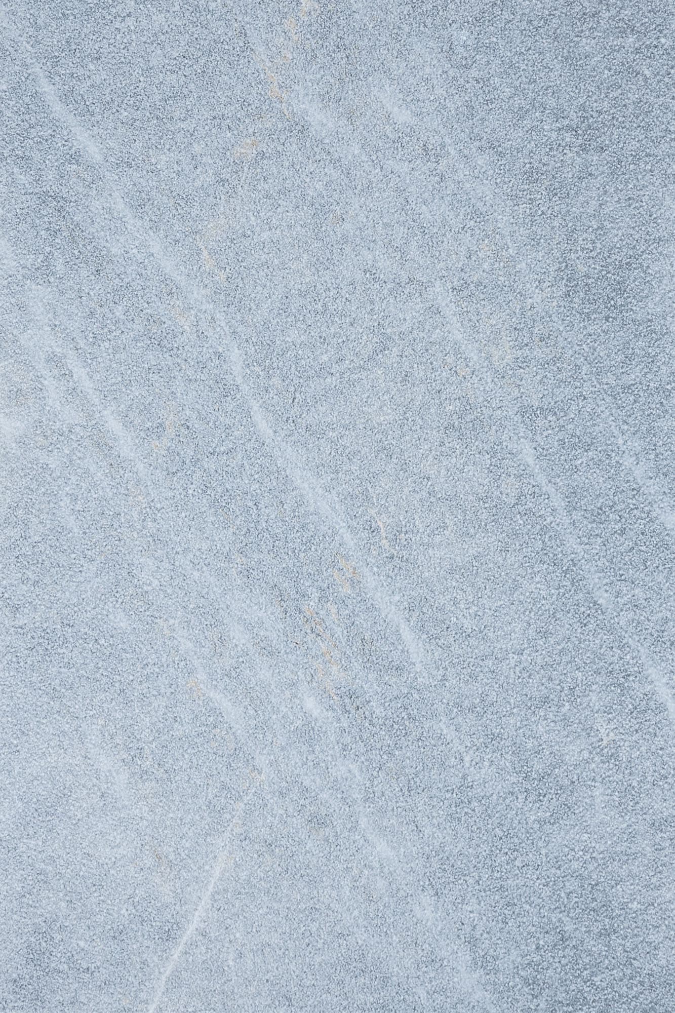 Close-up of Stonelux's Arctic Grey Marble Sand Blasted 16x24 3cm Paver. The natural stone features a light grey hue with subtle veining and a textured sandblasted finish, ideal for enhancing outdoor spaces with a modern, elegant look.