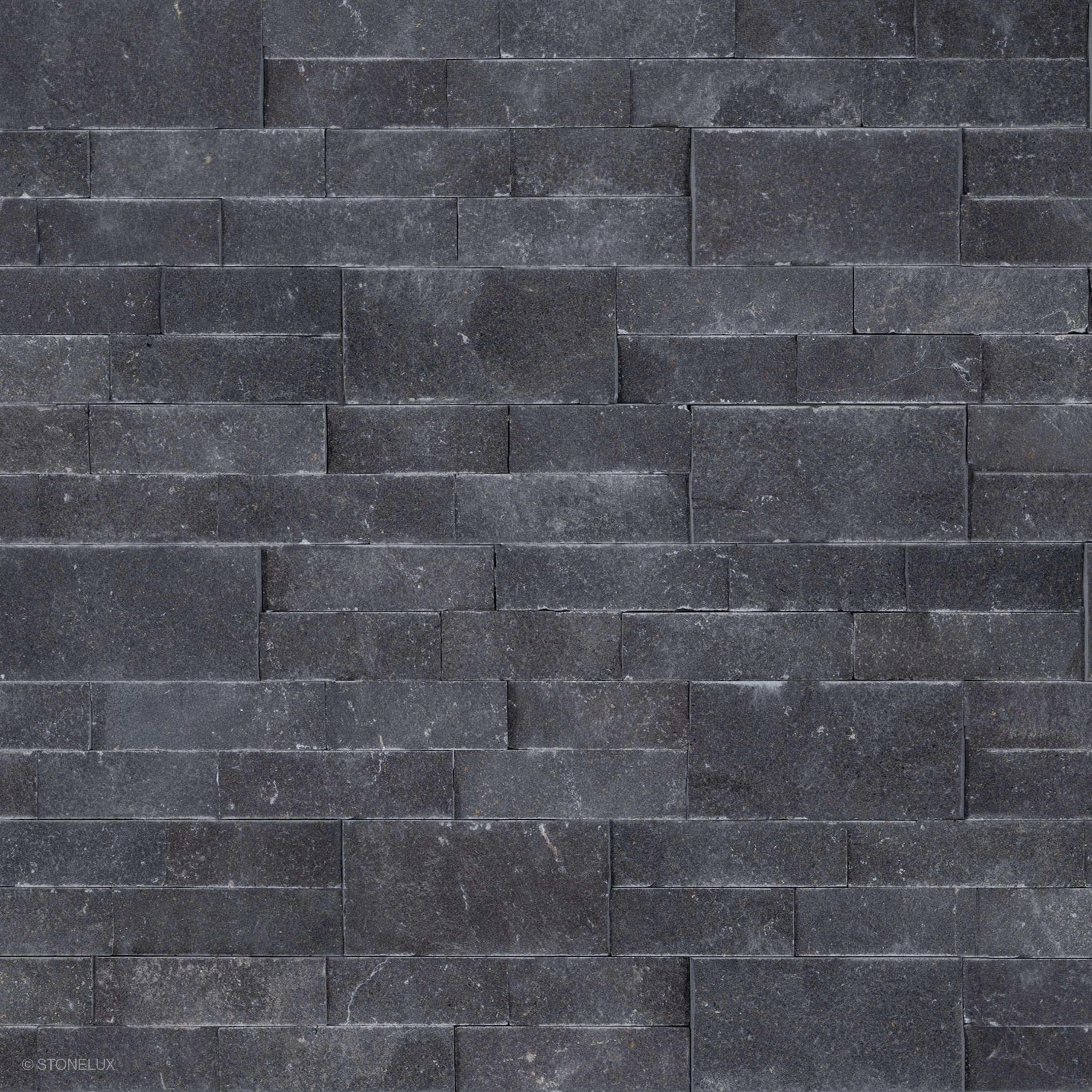 Close-up view of Black Basalt Splitface Ledger Panel - 6x24 by STONELUX, showcasing the natural basalt texture with rich dark tones and a rugged, splitface finish. Ideal for wall veneers, offering a sophisticated, modern aesthetic for hardscape projects.