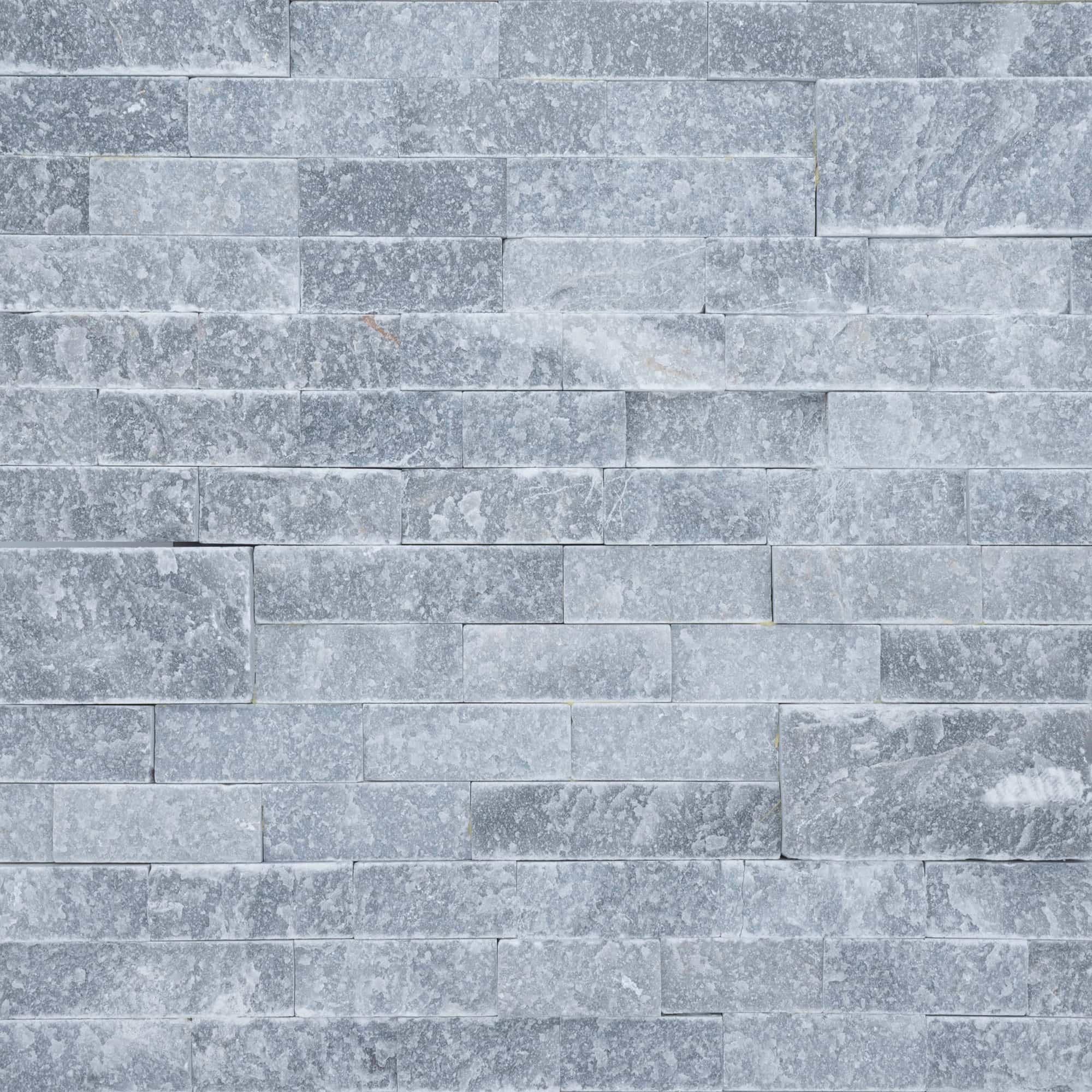 Close-up image of Arctic Grey Marble Splitface Ledger Panel in 6x24 size. The natural stone features a textured splitface finish with varying shades of grey and subtle veining, ideal for creating elegant and modern hardscapes and wall installations.
