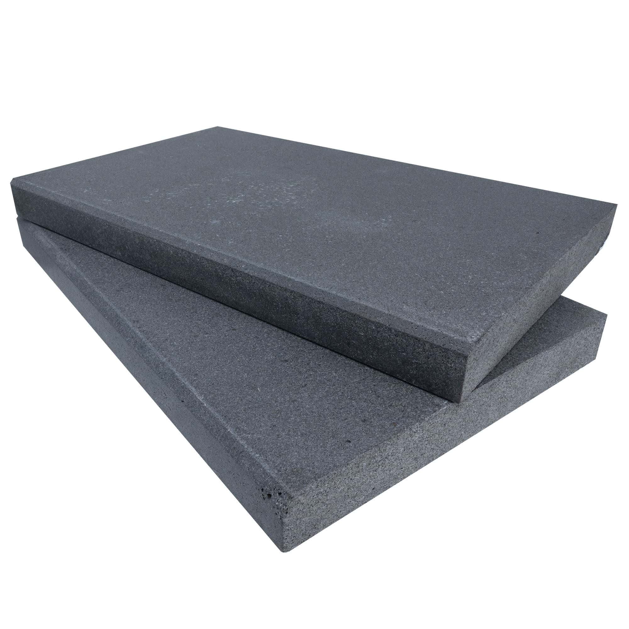 Close-up of Black Basalt Tumbled+Brushed 14x24x2 Eased Edge Coping by STONELUX. This natural stone features a textured, dark gray surface with a smooth beveled edge, ideal for pool coping or patio projects. Durable and elegant for modern hardscapes.