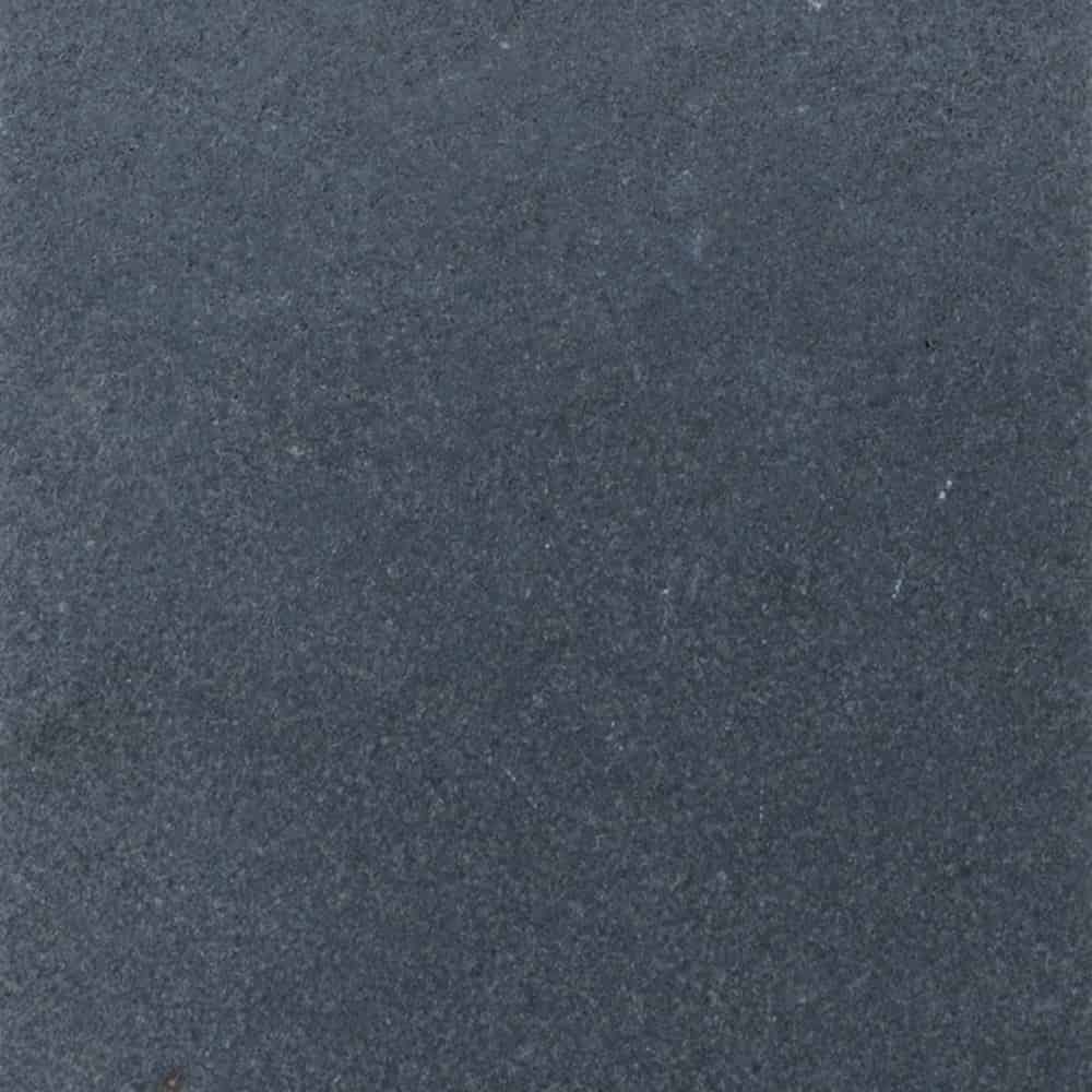 Close-up view of a dark gray, textured stone surface of Black Basalt, with a slightly rough and matte appearance. Subtle variations in color and small specks are scattered throughout.