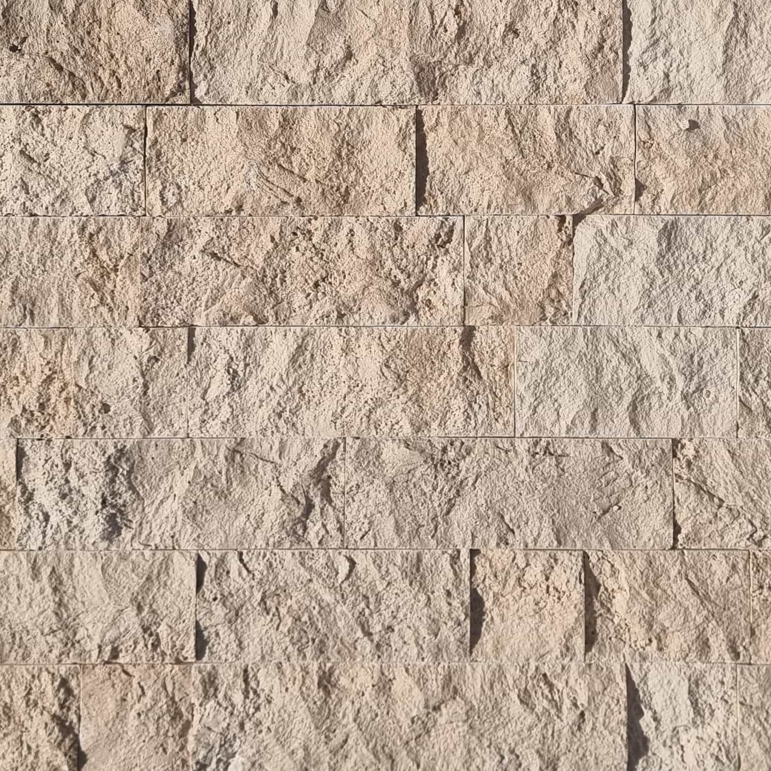 Close-up of Ivory Travertine Splitface Veneer showcasing its textured surface and natural beige tones. The 4" x Free Length travertine features subtle veining, ideal for adding rustic elegance to facades and accent walls. Perfect for stone veneer proje...
