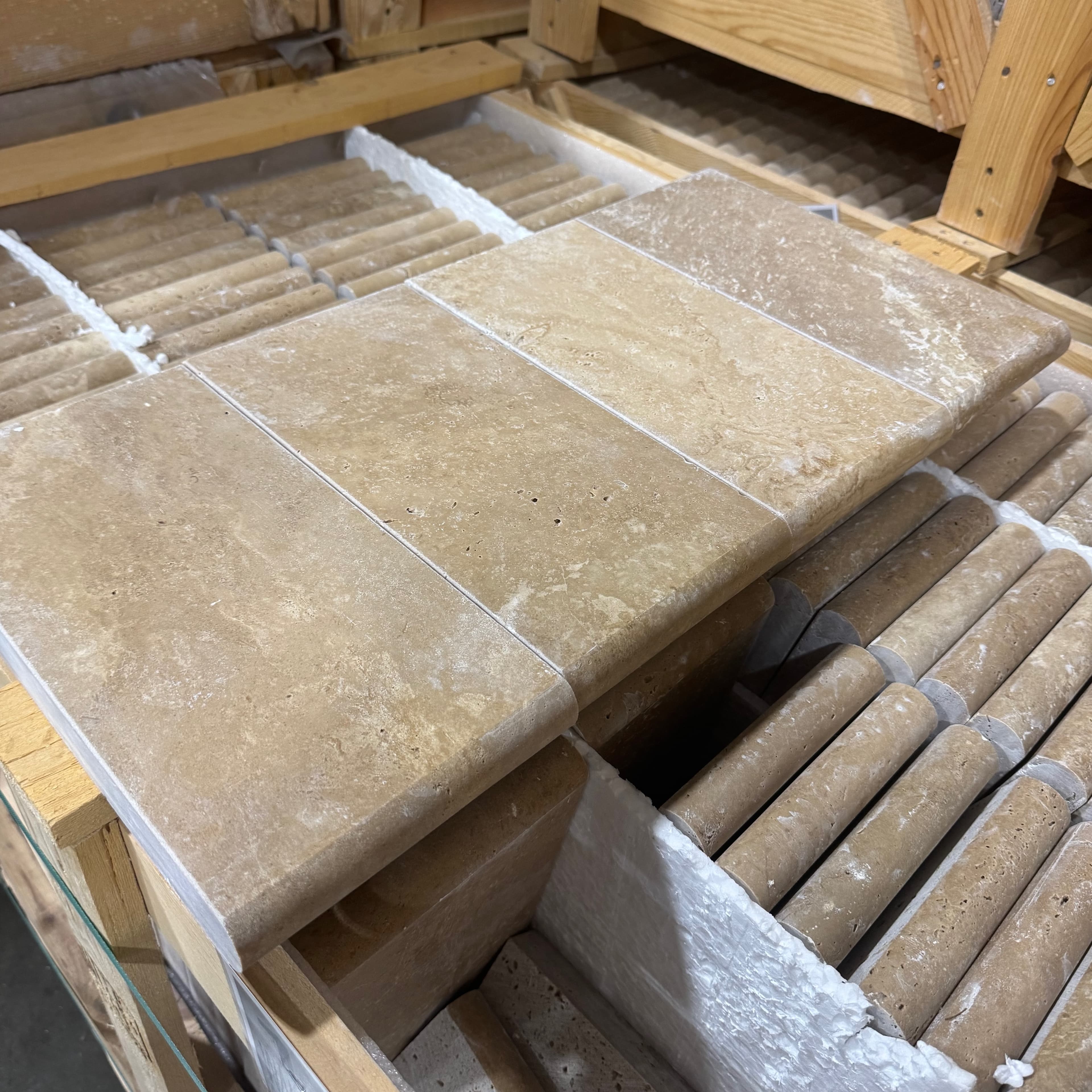 Close-up of Walnut Travertine Tumbled 6x12x3cm Single Bullnose Coping. The premium travertine features a warm, earthy tone with subtle veining and a smooth, tumbled finish, ideal for pool coping or patio edges in luxury hardscape designs.