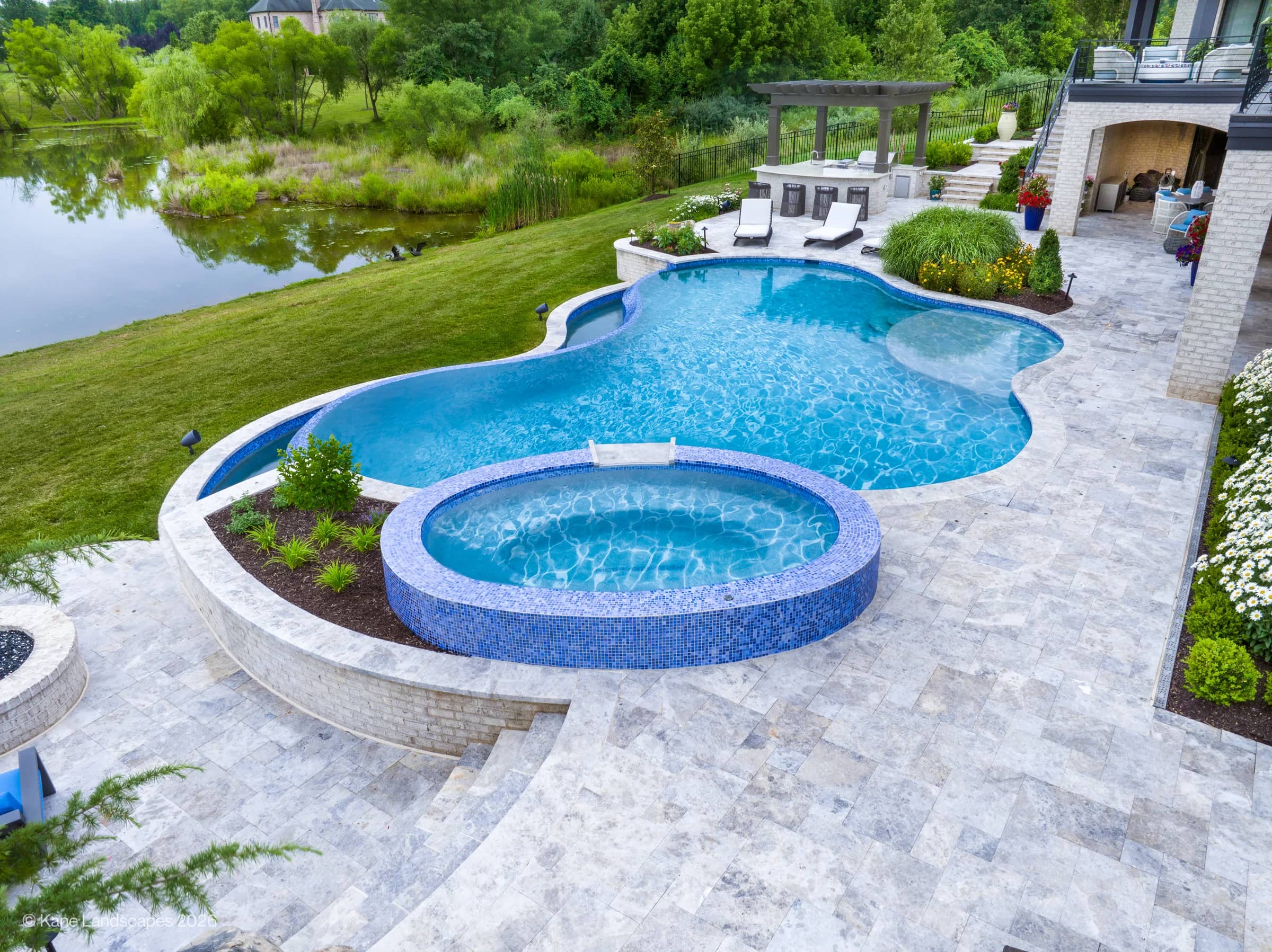 Tundra Grey Marble Pool Terrace with Curved Walls and Blue-Tiled Spa