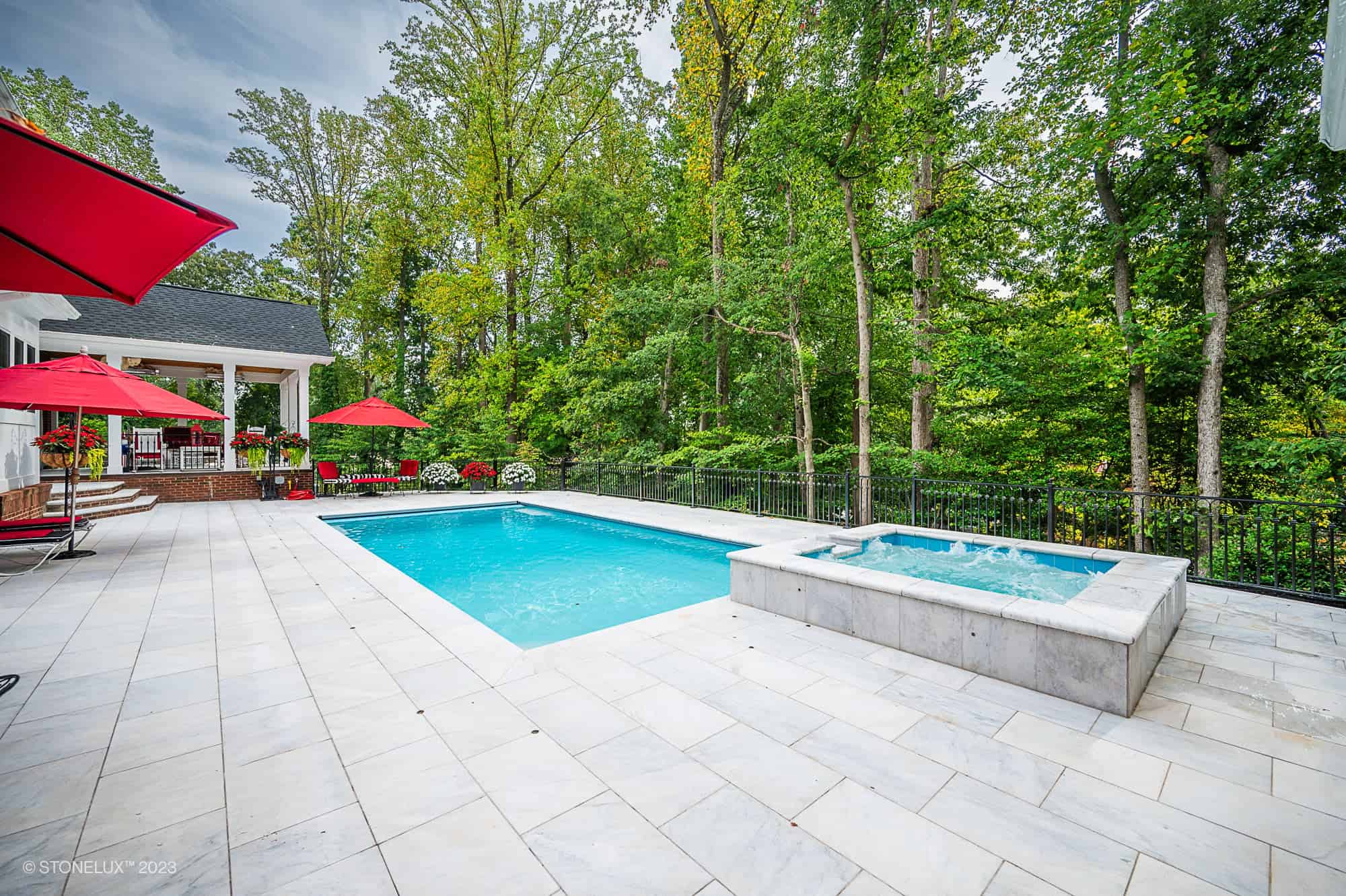 Afyon White Marble pool coping and light marble pavers installed around a pool and spa in Burke, VA.