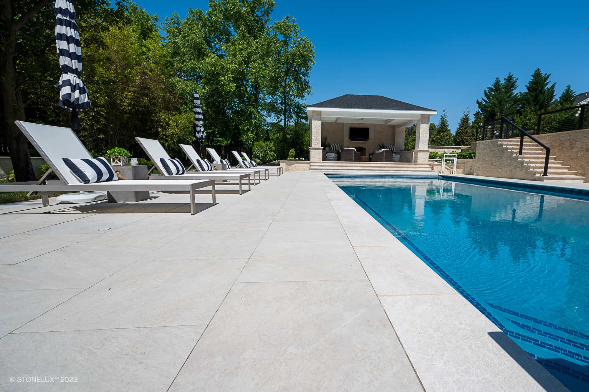 Pera Cream Marble pool coping and pavers installed around a residential pool project in Ashburn, VA.