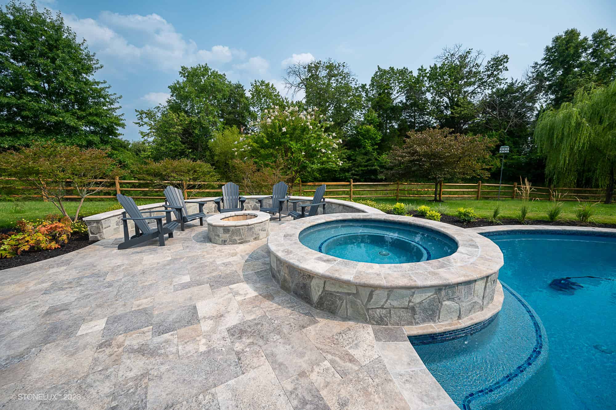 Silver Travertine pool coping installed around a backyard pool and spa in Chantilly, VA.