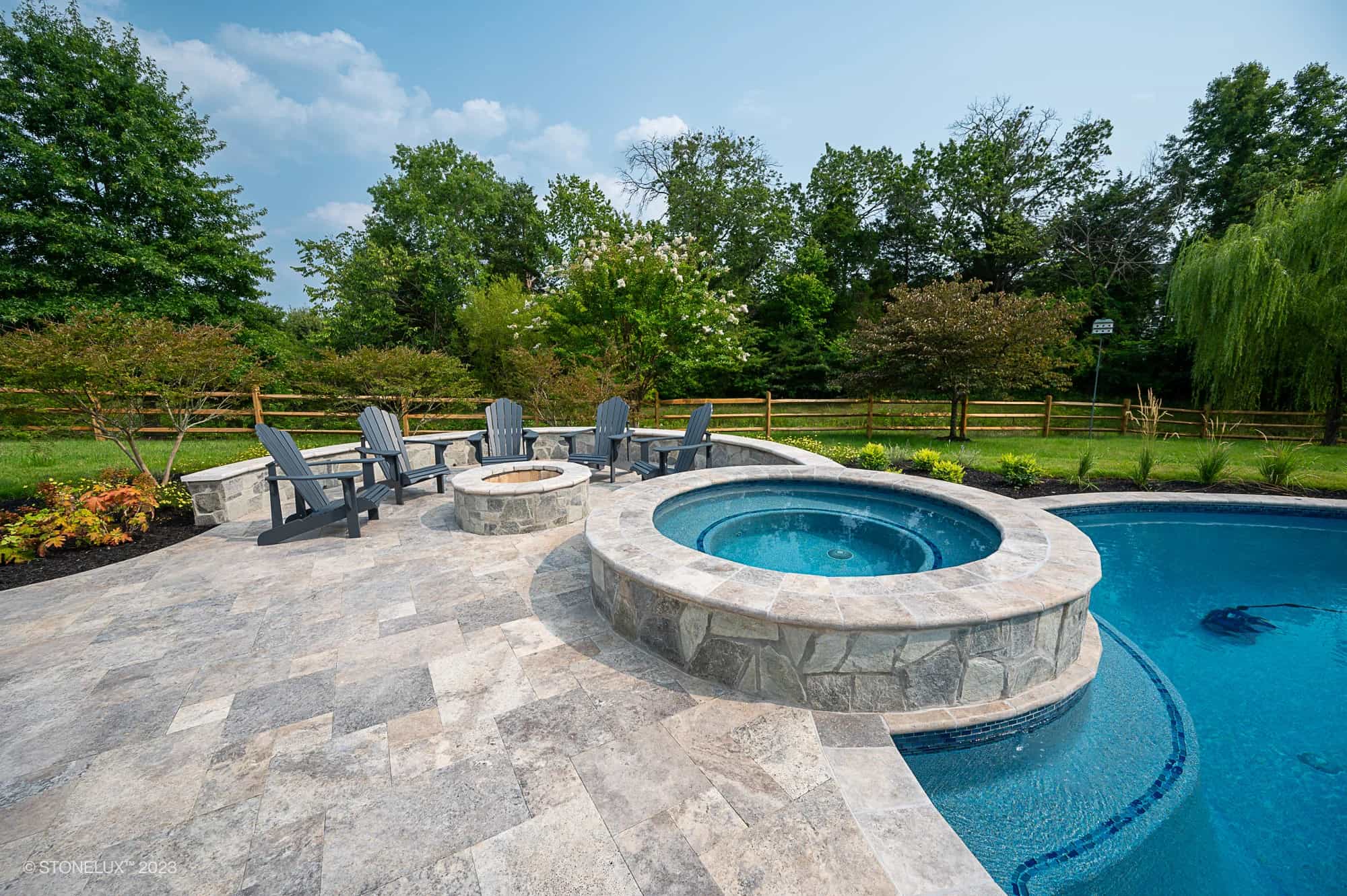 Silver Travertine bullnose pool coping installed around a backyard pool and spa in Chantilly, VA.